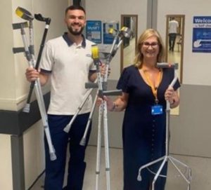 Two NHS staff holding recycled walking aids