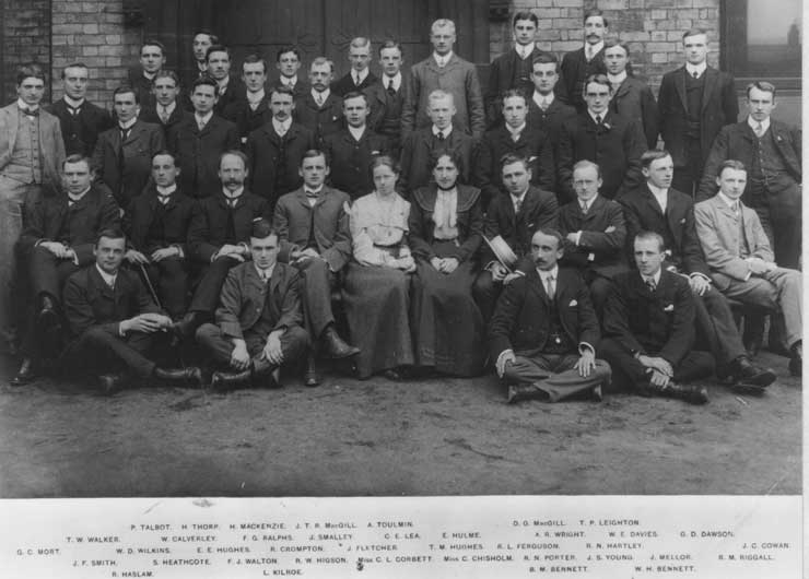 Black-and-white formal group photograph of final-year medical students arranged in rows, showing two women seated among a large group of male students, including Dr Corbett and Dr Chisholm.