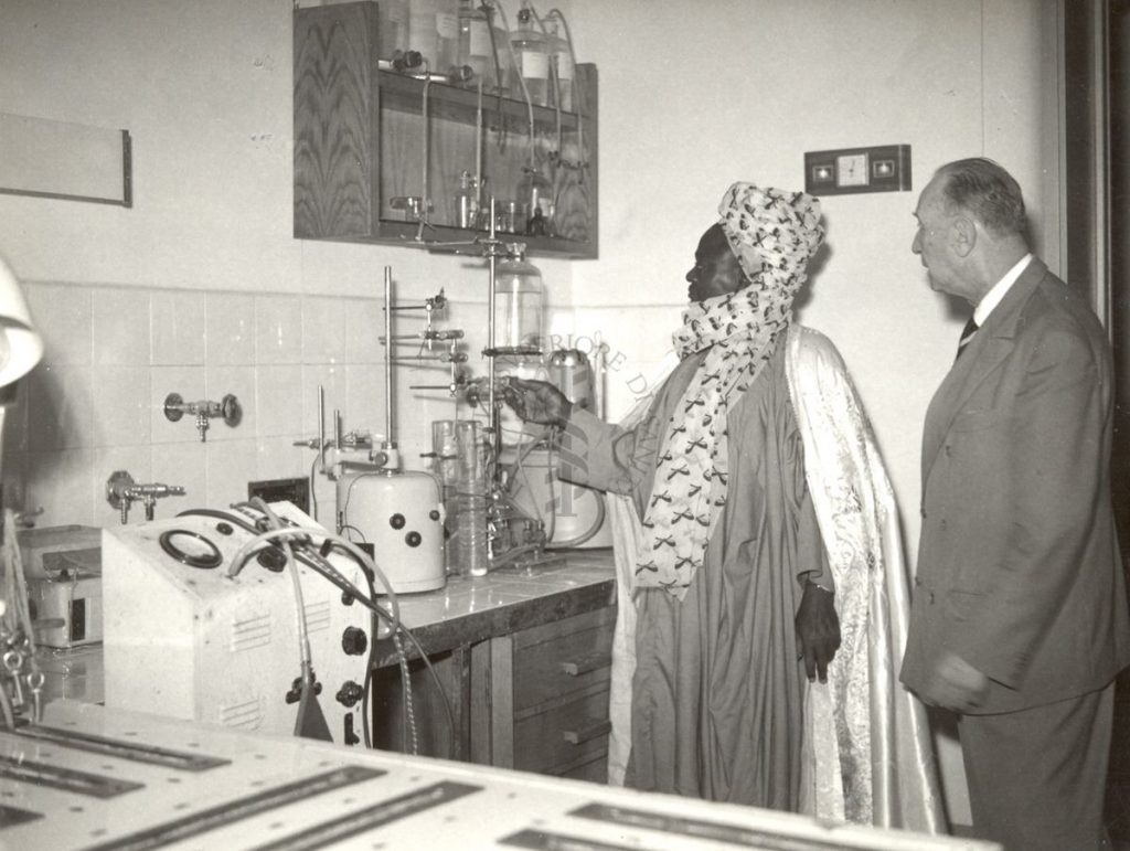 Photograph of a visitor in traditional Nigerian clothes in a laboratory