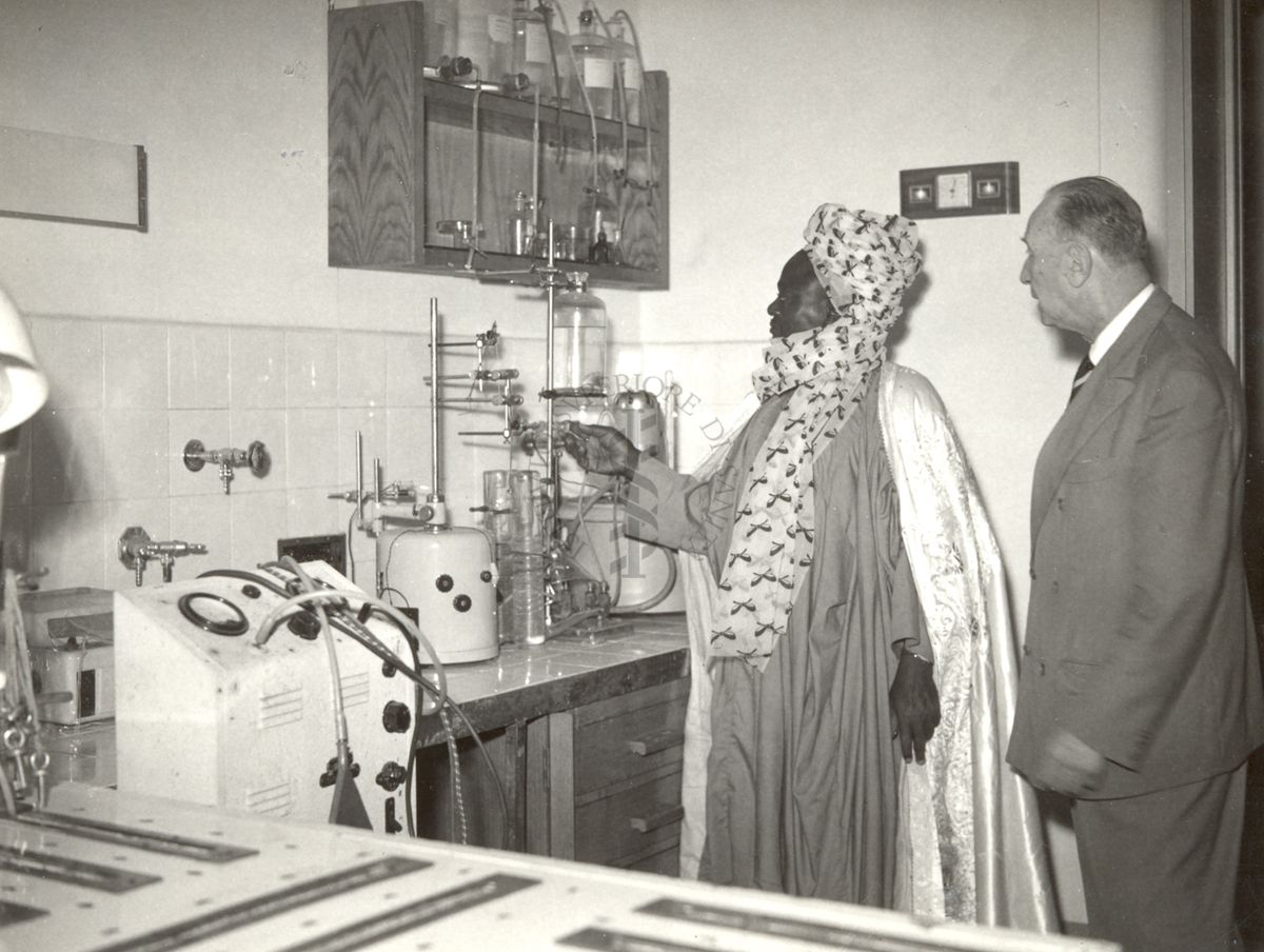 Dr Michael Okpara 1960 Photograph of a visitor in traditional Nigerian clothes in a laboratory