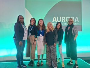 Zhiteng Feng & other members of action learning set stood at an Aurora conference