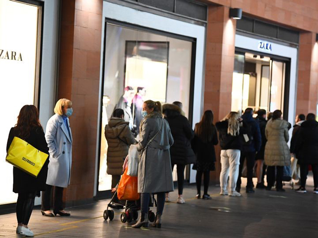 Shoppers queuing outside a clothes shop