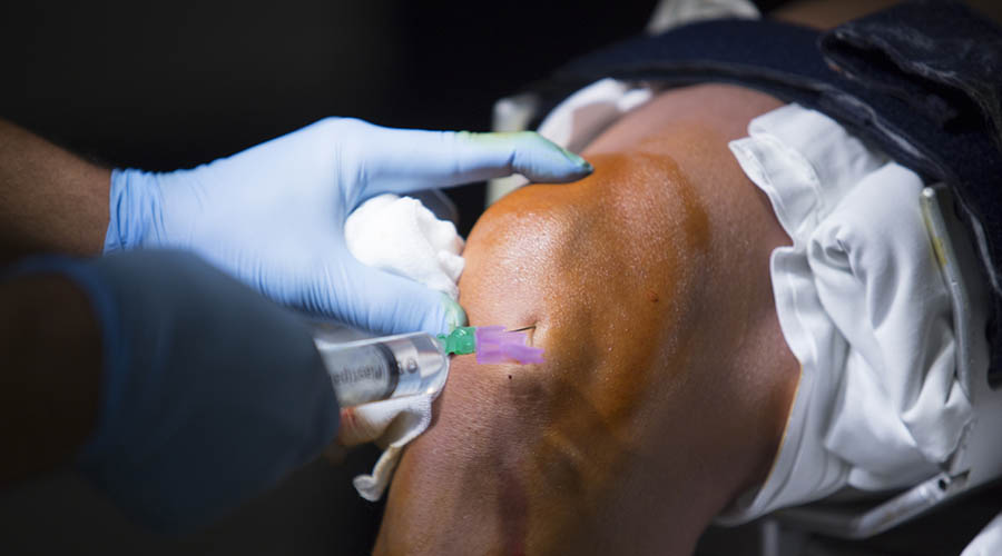 Man receiving injection in the knee