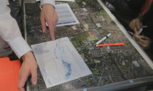 Image of two people working with an aerial city view map