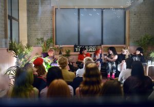 Panel discussion with six female speakers seated on a couch in front of an audience under a “Talking Threads” sign.