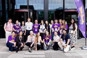 Large group of people wearing purple university shirts 
