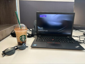 Dark glasses, coffee, and laptop computer on a table